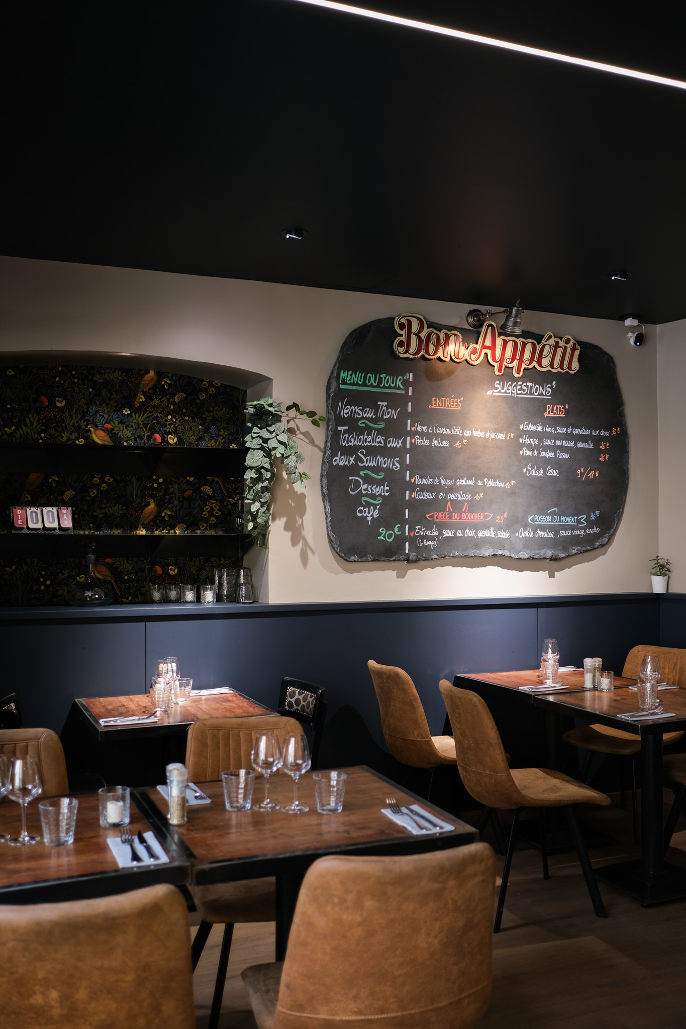Décoration intérieure de restaurant avec plafond noir, murs bicolores et ambiance chaleureuse
