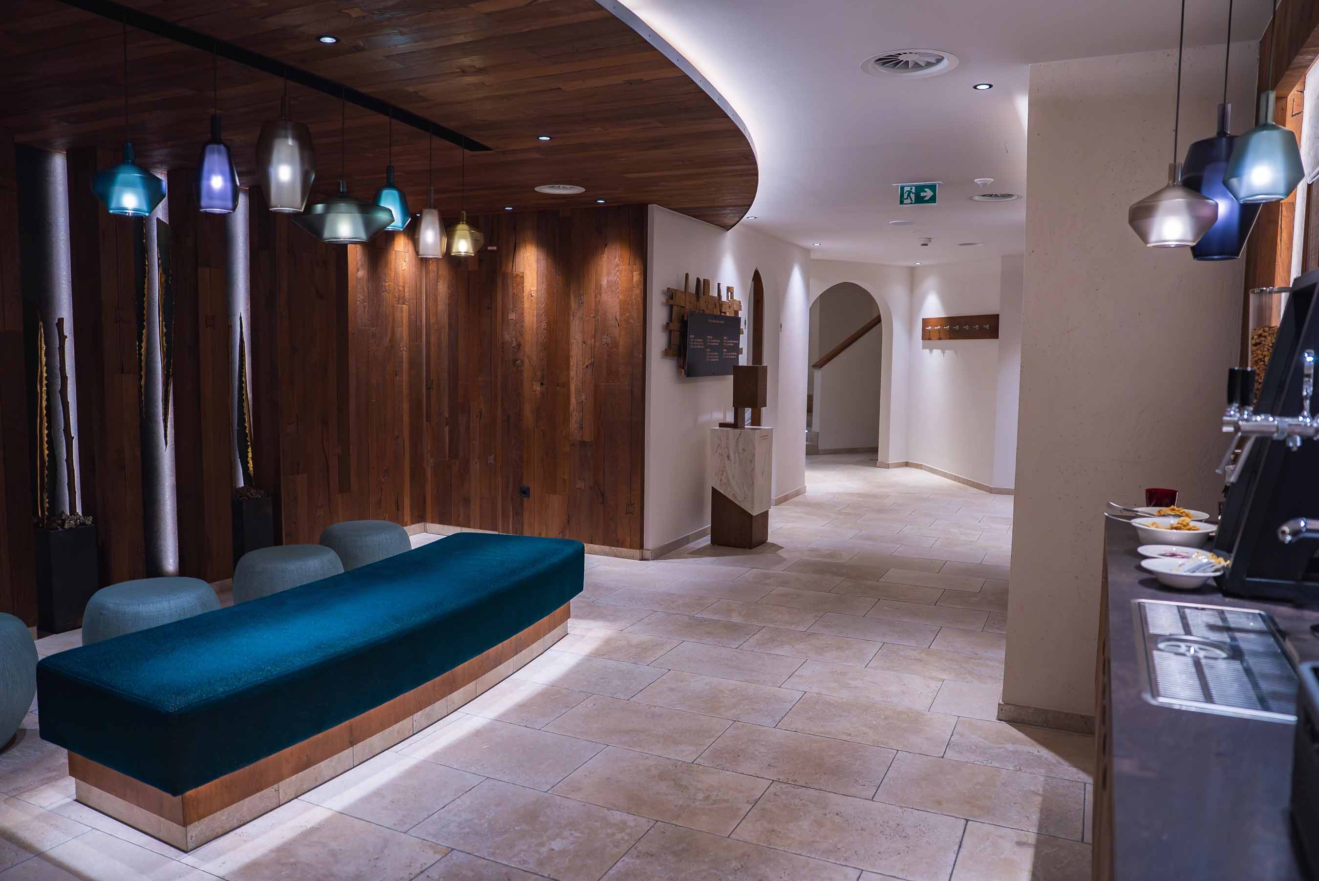 Espace professionnel contemporain avec murs habillés de bois, sol en pierre et suspensions design