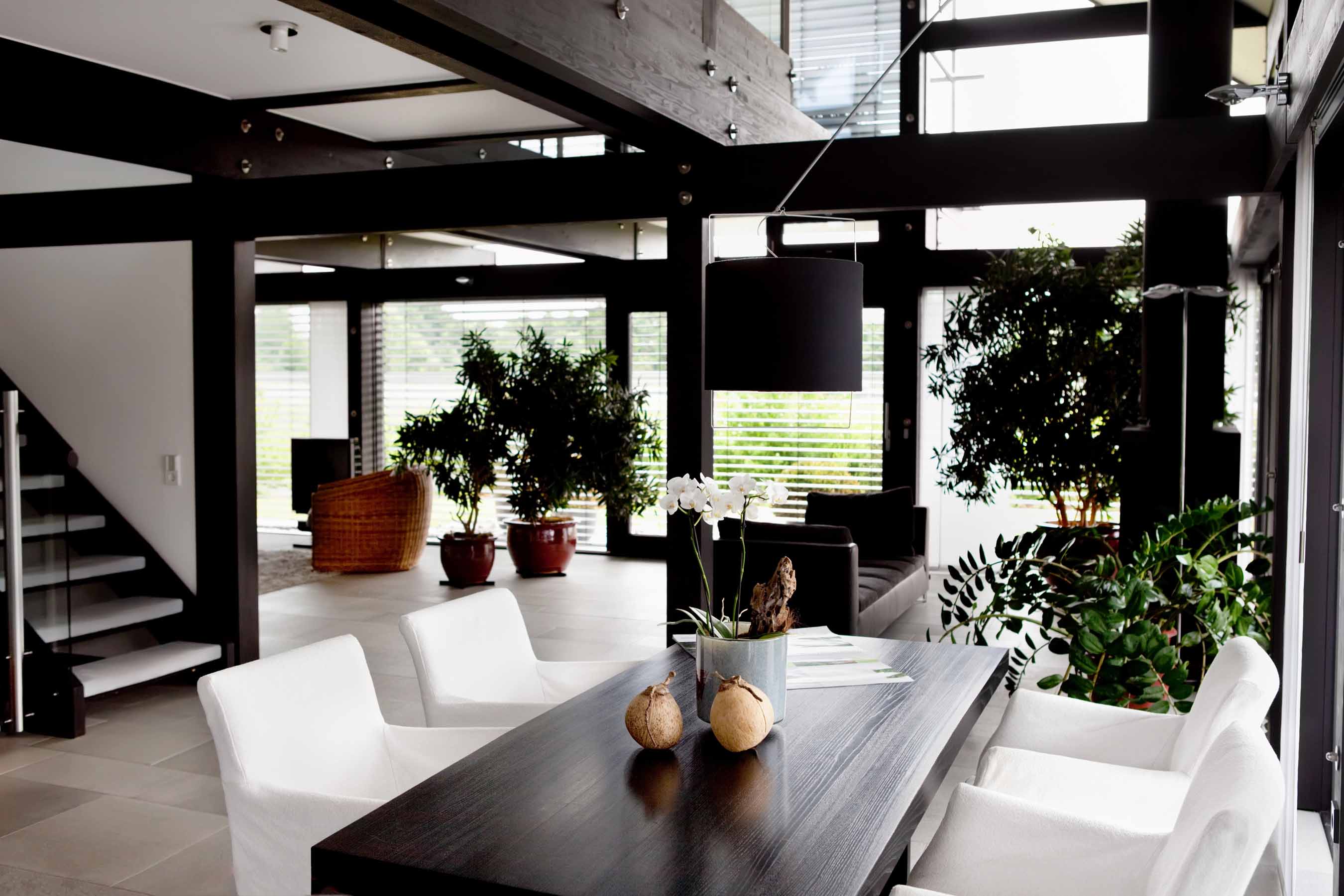 Salle à manger contemporaine avec poutres en bois foncé, murs blancs et décoration moderne